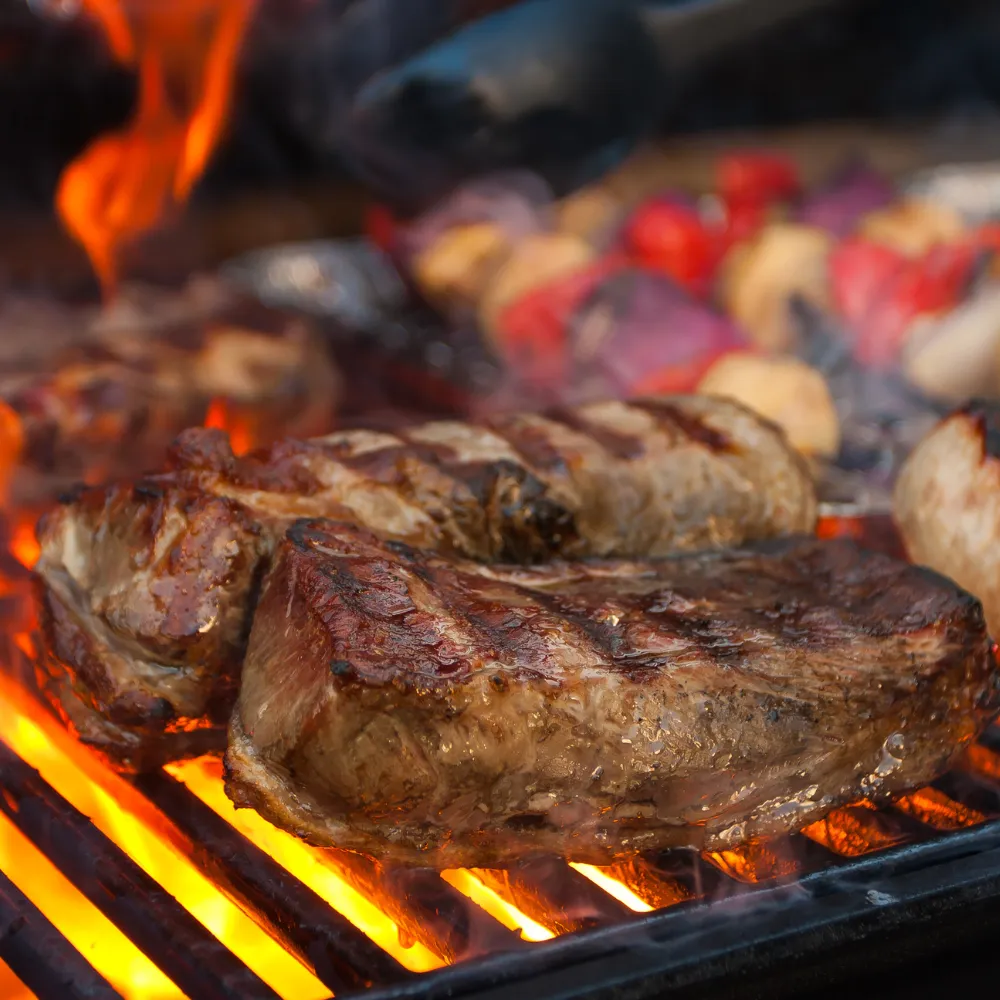 Cortes de carne asándose en la parrilla con brasas Rucapellan